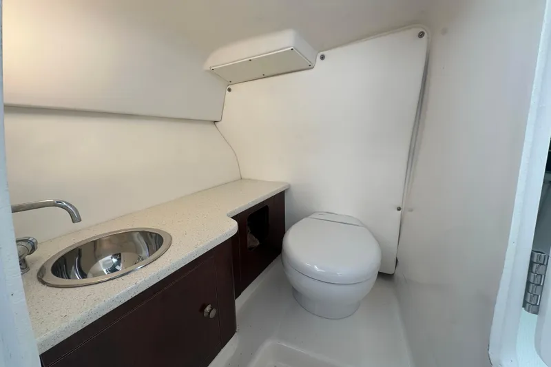 Slide: The Image of 2022 Robalo R247 Dual Console boat bathroom with sink and toilet. - 12