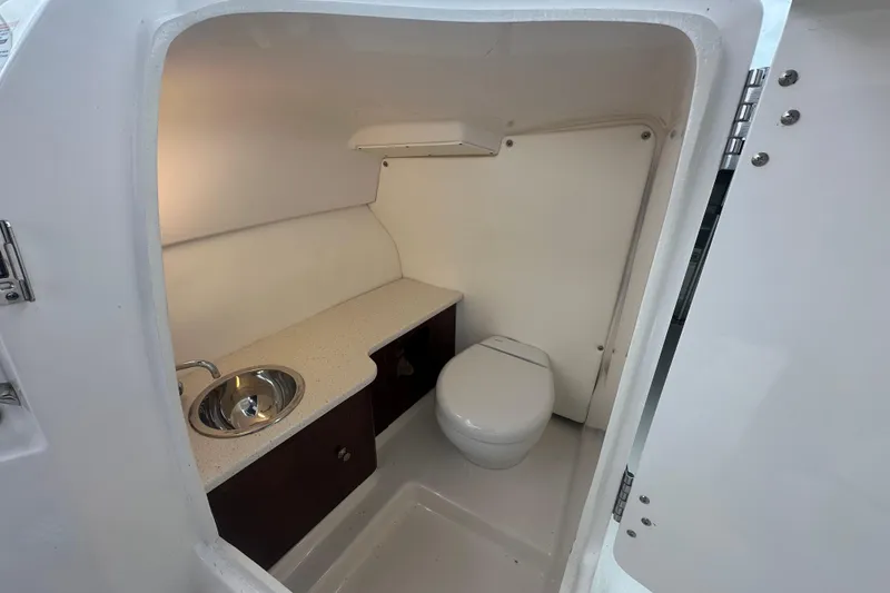 Slide: The Image of 2022 Robalo R247 Dual Console boat interior with sink and toilet. - 13