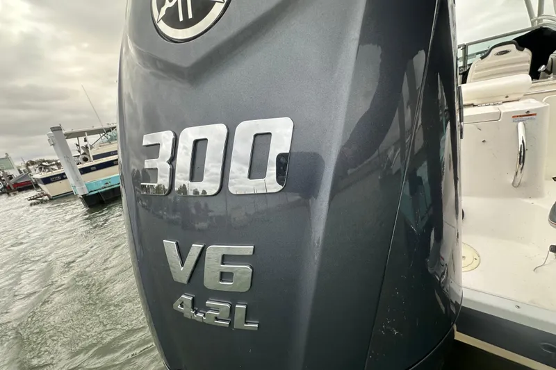 Slide: The Image of 2022 Robalo R247 Dual Console with 300 V6 4.2L engine at marina. - 15