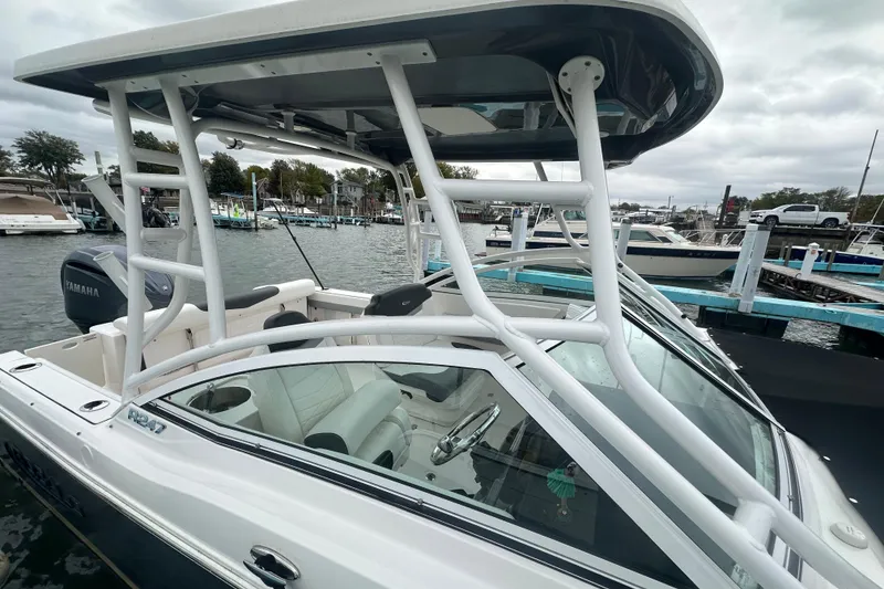 Slide: The Image of 2022 Robalo R247 Dual Console boat docked at marina, featuring Yamaha engine. - 18