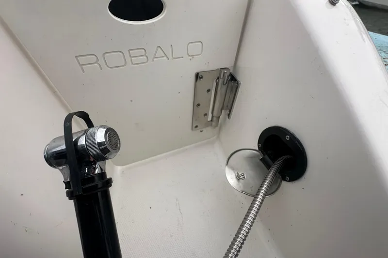 Slide: The Image of 2022 Robalo R247 Dual Console boat interior with shower hose and fittings. - 21