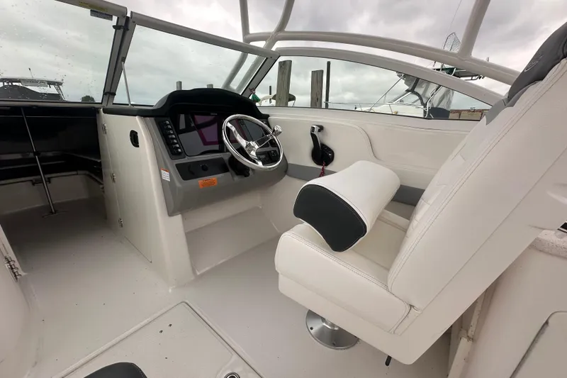 Slide: The Image of 2022 Robalo R247 Dual Console boat interior with steering wheel and seating. - 8