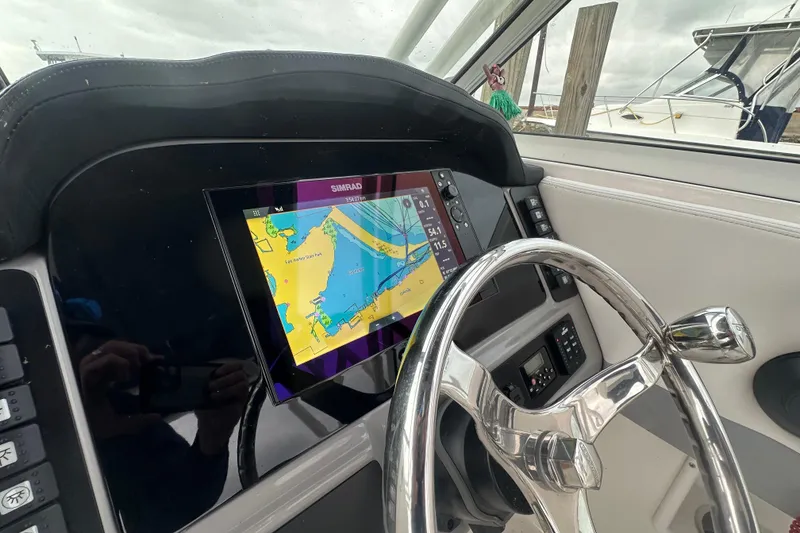 Slide: The Image of 2022 Robalo R247 Dual Console helm with Simrad navigation display and steering wheel. - 9