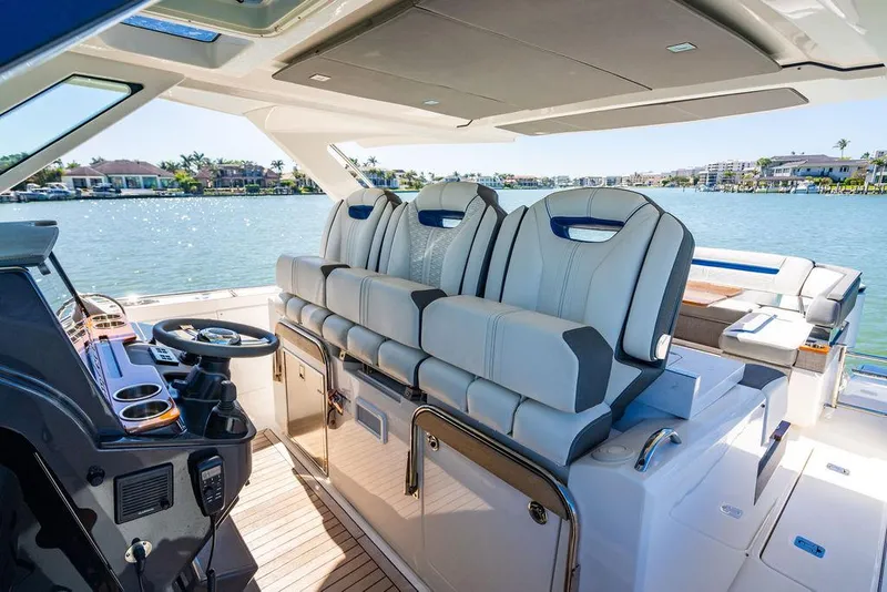 Slide: The Image of 2021 Tiara Yachts 38 LS interior with luxurious seating and helm, overlooking serene waters. - 17