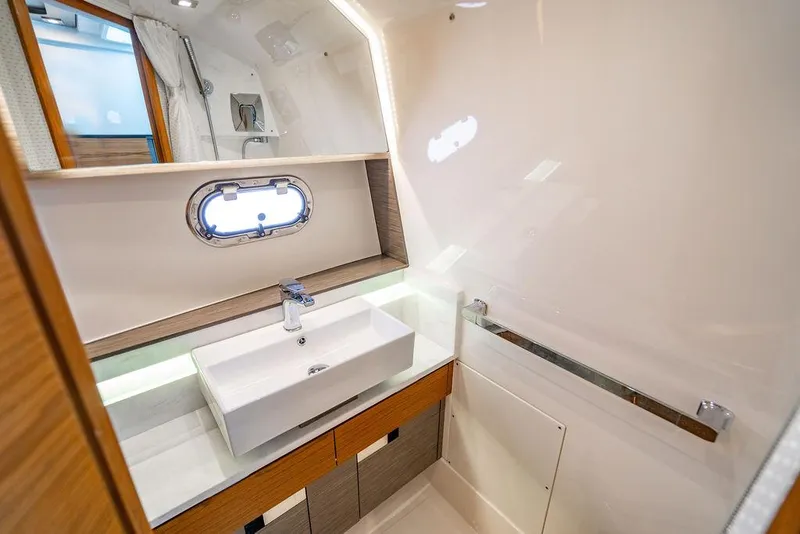Slide: The Image of Luxurious bathroom interior of 2021 Tiara Yachts 38 LS with modern sink and porthole window. - 22