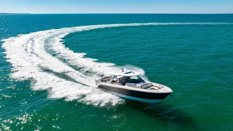 Slide: The Image of 2021 Tiara Yachts 38 LS cruising on open water, creating a dynamic wake. - 25