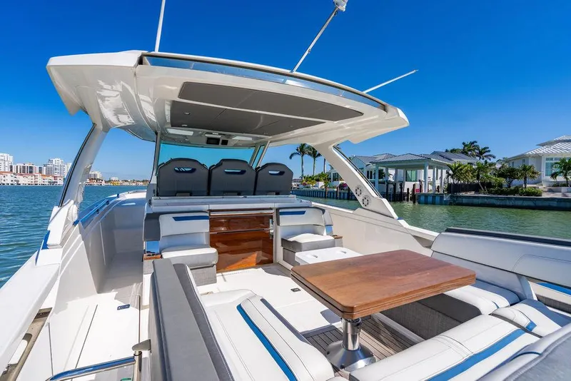 Slide: The Image of 2021 Tiara Yachts 38 LS luxury boat interior with seating and table, docked by waterfront homes. - 6