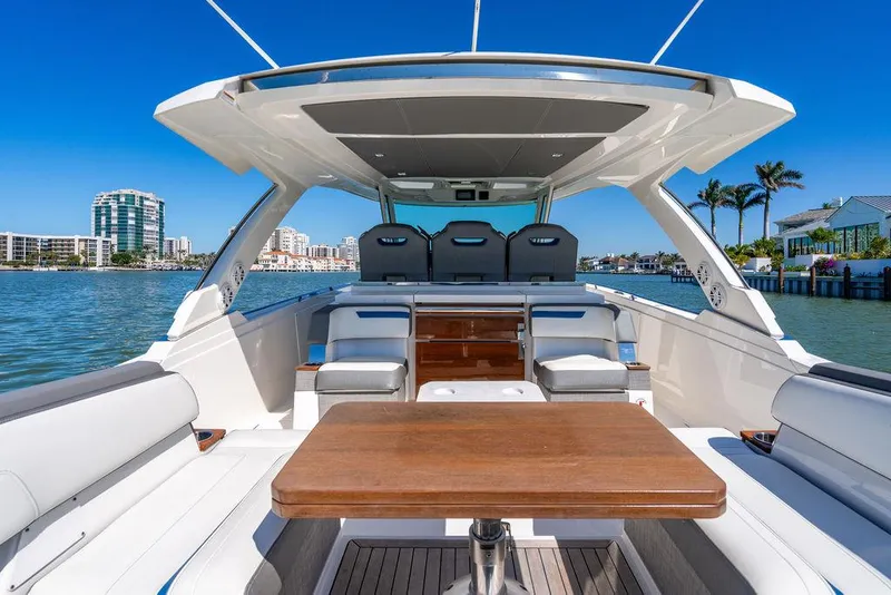 Slide: The Image of 2021 Tiara Yachts 38 LS luxury boat interior with seating and table, docked in sunny marina. - 7
