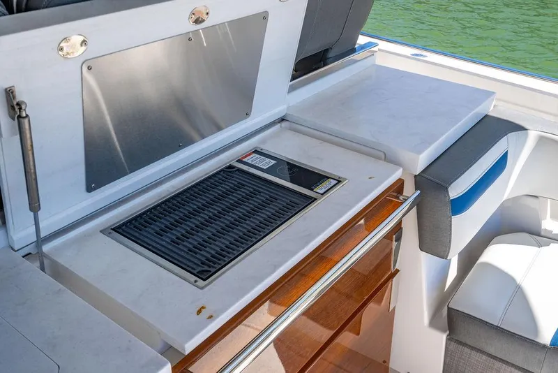 Slide: The Image of Outdoor kitchen area on 2021 Tiara Yachts 38 LS, featuring a built-in grill and seating. - 8