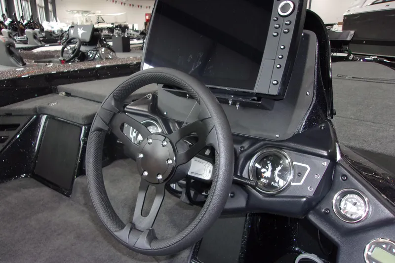 Slide: The Image of 2025 Skeeter ZXR21 boat dashboard with steering wheel and digital display. - 11