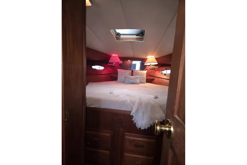 Slide: The Image of Cozy cabin interior of 1991 Cooper Marine Prowler with bed and warm lighting. - 11