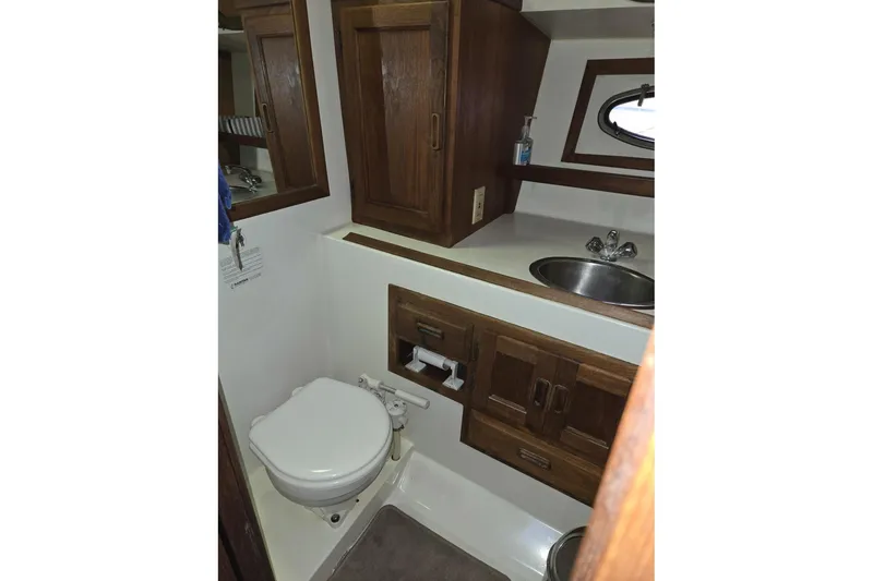 Slide: The Image of 1991 Cooper Marine Prowler boat bathroom with wooden cabinets and compact sink. - 15