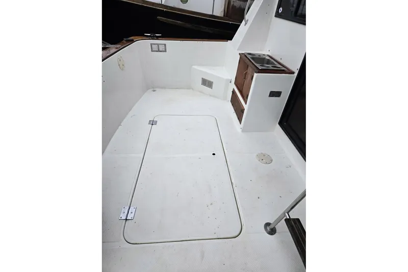 Slide: The Image of 1991 Cooper Marine Prowler boat deck with storage hatch and seating area. - 16