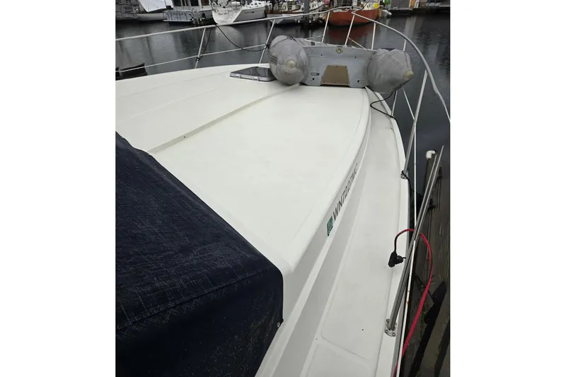 Slide: The Image of 1991 Cooper Marine Prowler boat docked, featuring a spacious deck and safety railings. - 19