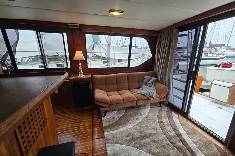 Slide: The Image of Interior of 1991 Cooper Marine Prowler yacht with cozy seating and marina view. - 4