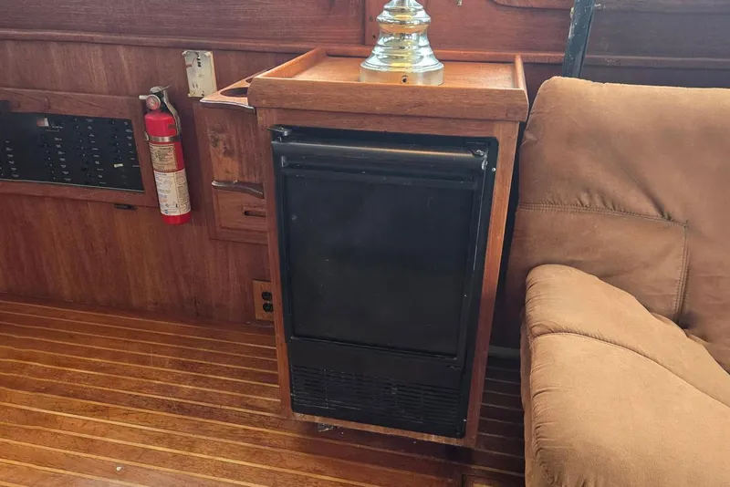 Slide: The Image of 1991 Cooper Marine Prowler interior with wood paneling, fire extinguisher, and compact fridge. - 5