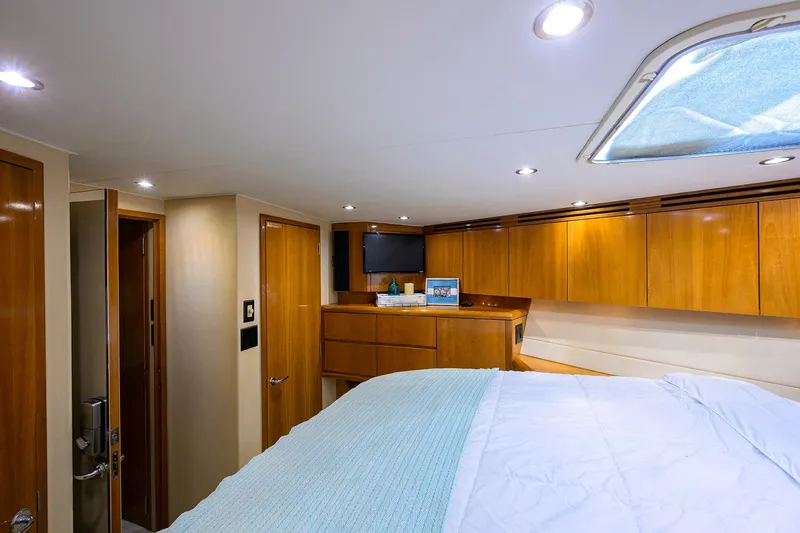 Slide: The Image of Luxurious cabin interior of 2001 Hatteras 60 Convertible yacht with wood finishes and cozy bedding. - 27