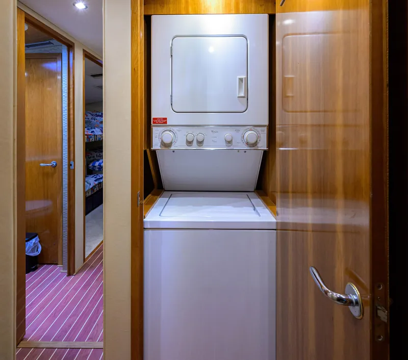 Slide: The Image of Laundry area with stacked washer and dryer in 2001 Hatteras 60 Convertible yacht. - 32