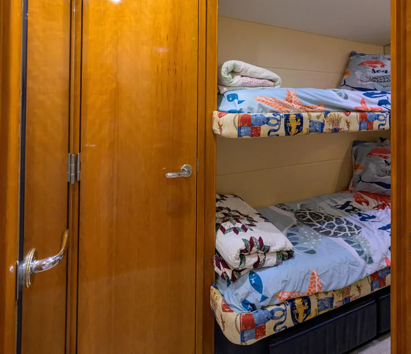 Slide: The Image of Bunk beds in 2001 Hatteras 60 Convertible yacht cabin with wooden door. - 33