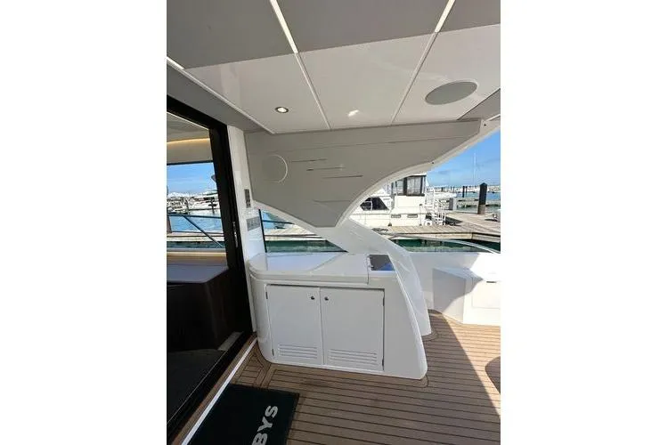 Slide: The Image of 2021 Sunseeker Predator 60 EVO yacht deck with sleek design and marina view. - 16