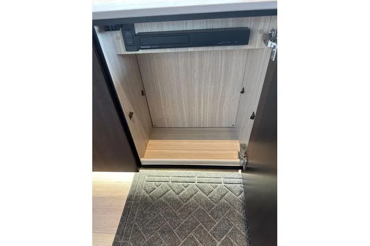 Slide: The Image of Open cabinet in 2021 Sunseeker Predator 60 EVO yacht interior, featuring wood finish and carpeted floor. - 36