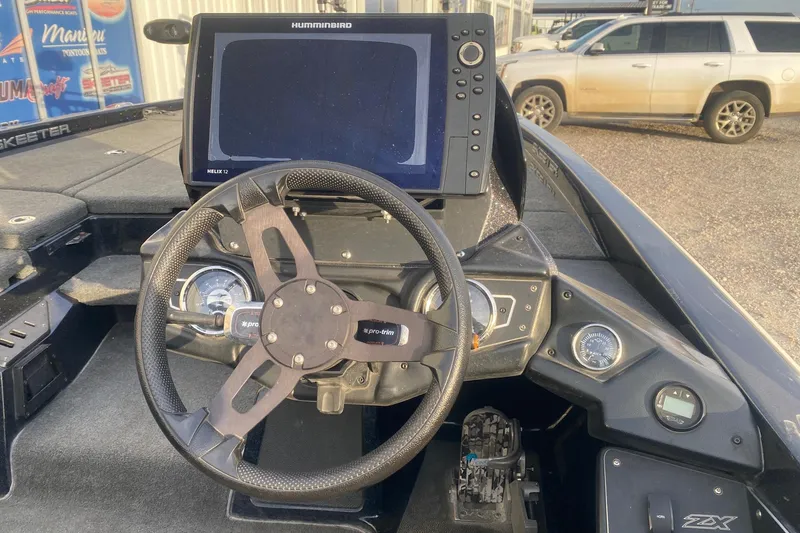 Slide: The Image of 2019 Skeeter ZX250 boat dashboard with steering wheel and Humminbird Helix 12 display. - 6
