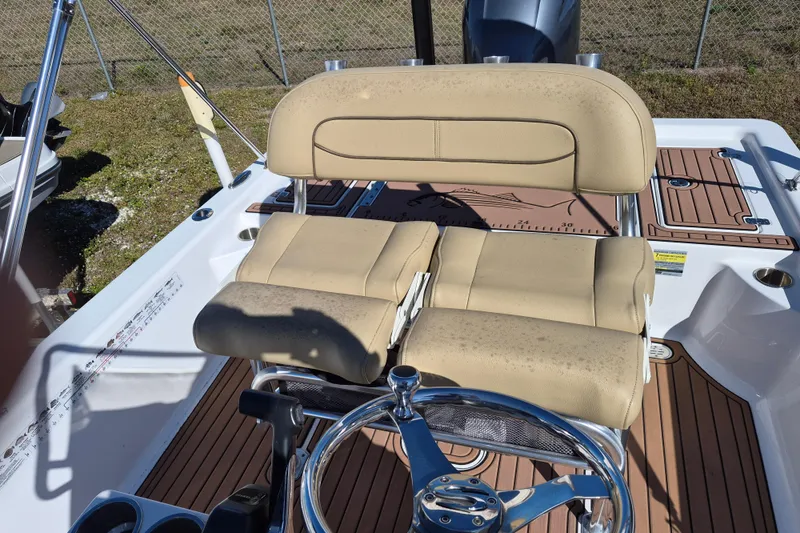 Slide: The Image of 2017 Sportsman Masters 207 Bay Boat helm with beige seating and steering wheel. - 12