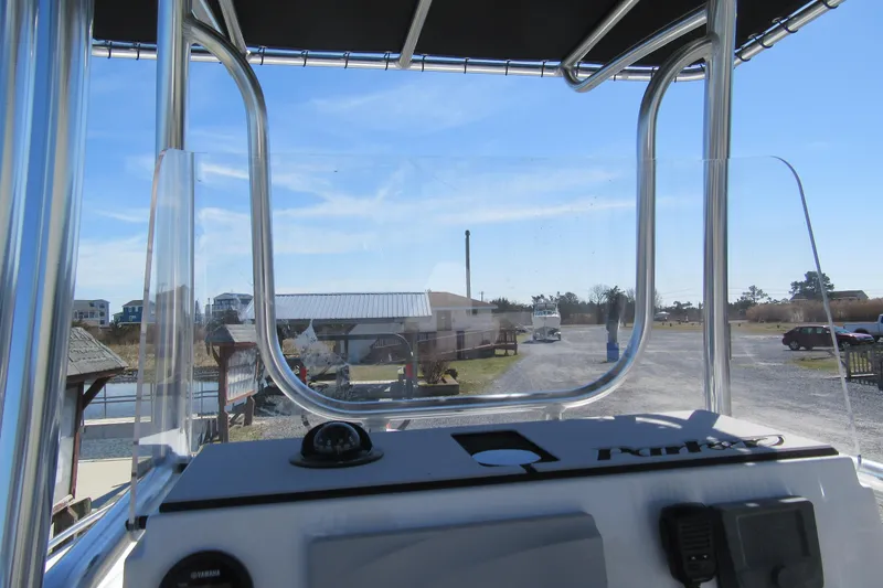 Slide: The Image of 2026 Parker 180 Coastal Elite boat console view with clear windshield and marina background. - 15