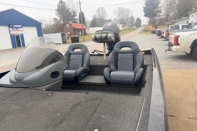 Slide: The Image of 2012 Lowe Stinger 18 HP boat with dual seats and windshield, parked outdoors. - 10