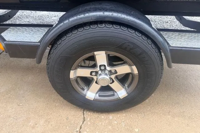 Slide: The Image of 2012 Lowe Stinger 18 HP trailer wheel with chrome rim and black tire. - 14