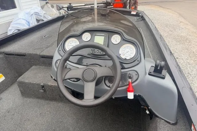 Slide: The Image of 2012 Lowe Stinger 18 HP boat dashboard with steering wheel and gauges. - 6