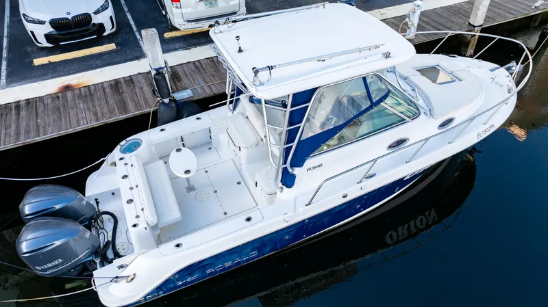 Slide: The Image of 2010 Robalo R305 Walkaround boat docked with twin engines. - 15