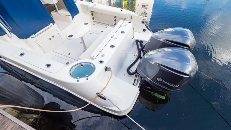 Slide: The Image of 2010 Robalo R305 Walkaround boat with Yamaha outboard engines docked on water. - 24