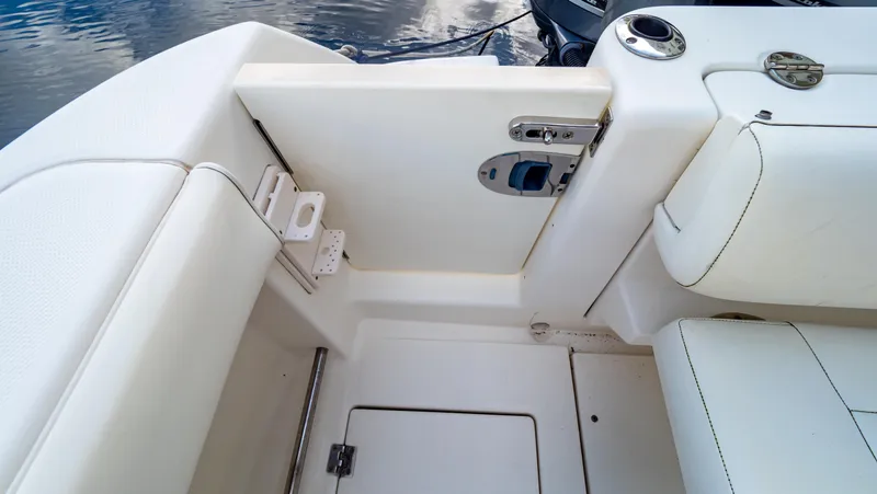 Slide: The Image of Interior view of 2010 Robalo R305 Walkaround boat, featuring white seating and storage compartments. - 25