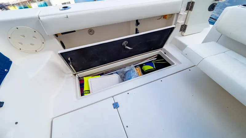 Slide: The Image of 2010 Robalo R305 Walkaround boat storage compartment with open hatch, revealing interior contents. - 26