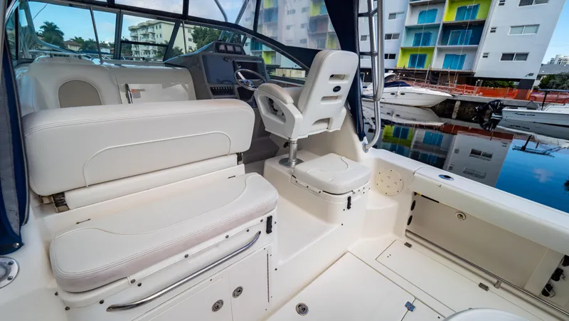 Slide: The Image of 2010 Robalo R305 Walkaround boat interior with seating and helm, docked near colorful buildings. - 32