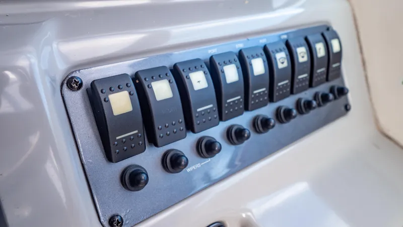 Slide: The Image of Control panel of 2010 Robalo R305 Walkaround boat with multiple switches. - 42