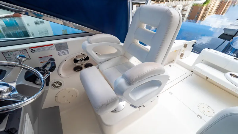 Slide: The Image of Captain's chair on 2010 Robalo R305 Walkaround boat, featuring sleek white upholstery. - 45