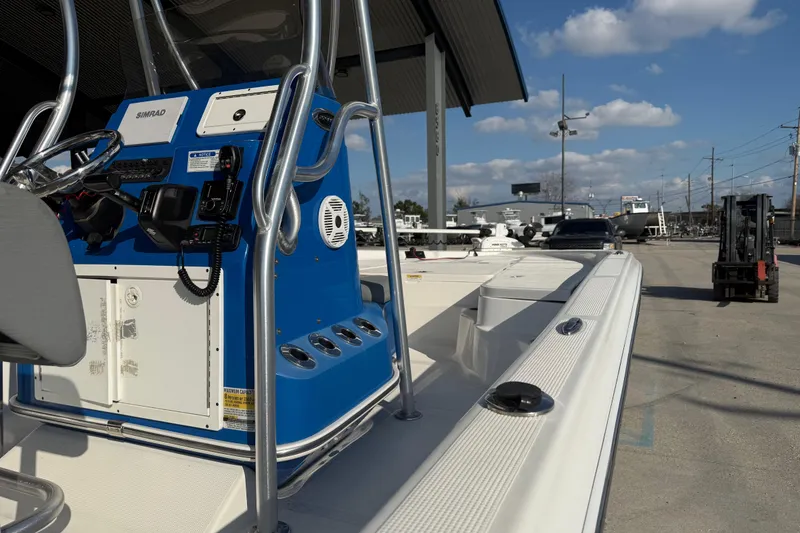 Slide: The Image of 2020 Aquasport 224 Bay boat with blue console, parked outdoors under clear sky. - 10