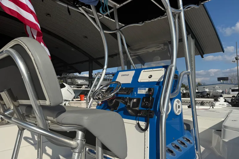 Slide: The Image of 2020 Aquasport 224 Bay boat console with steering wheel and American flag. - 9