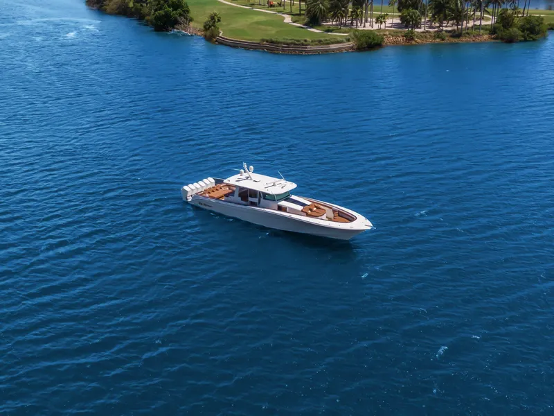 Slide: The Image of 2023 HCB 65 Estrella yacht cruising on blue water near a lush green shoreline. - 3