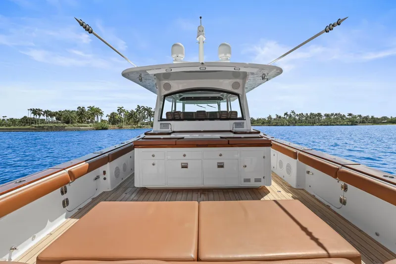Slide: The Image of 2023 HCB 65 Estrella luxury yacht interior with brown seating, ocean view, and palm trees. - 31