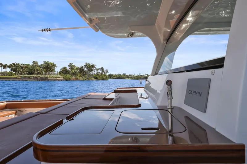 Slide: The Image of 2023 HCB 65 Estrella yacht with sleek deck design and Garmin equipment, cruising near tropical shoreline. - 33