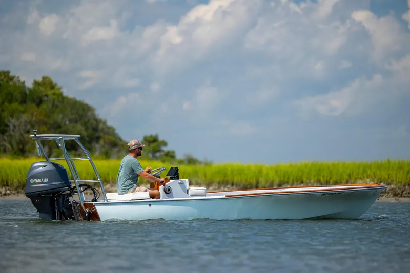Slide: The Image of 2023 Custom Carolina 18 Flats boat cruising on water with Yamaha engine. - 14