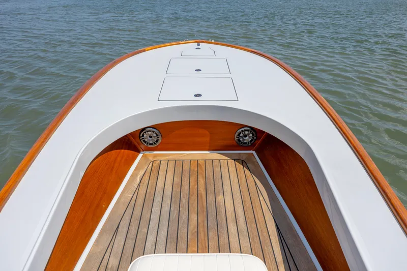 Slide: The Image of Custom Carolina 18 Flats boat deck with wood finish, 2023 model, on calm water. - 16