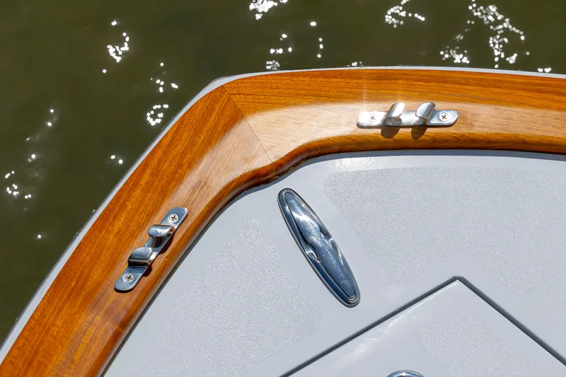 Slide: The Image of Custom Carolina 18 Flats 2023 boat deck with polished wood and metal fittings. - 18