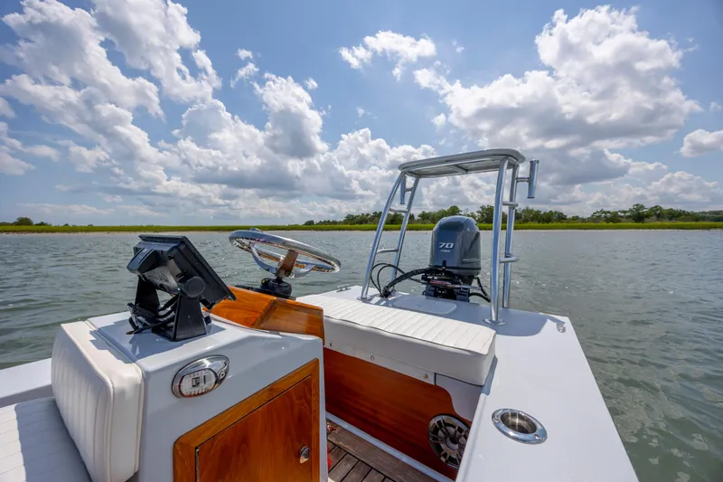 Slide: The Image of 2023 Custom Carolina 18 Flats boat on water under a partly cloudy sky. - 20