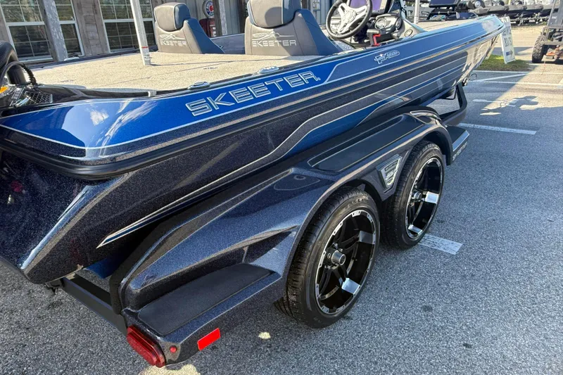 Slide: The Image of 2018 Skeeter FX20 boat with sleek blue design and dual-axle trailer. - 1