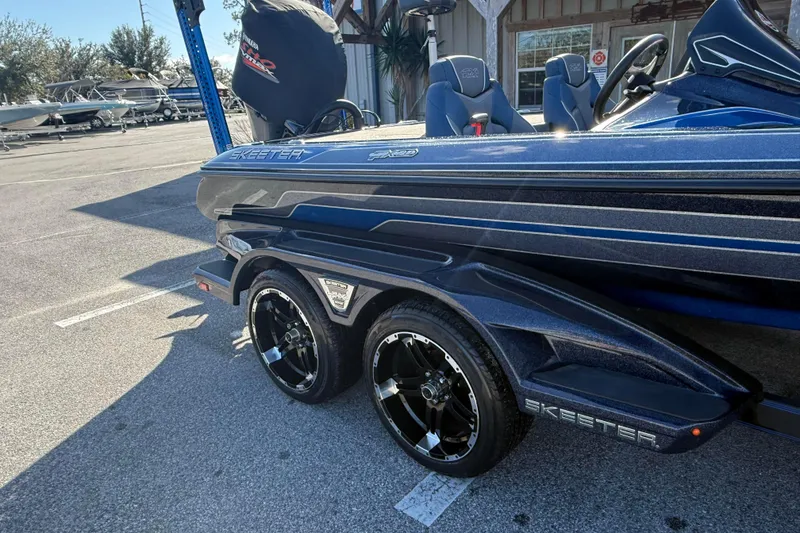 Slide: The Image of 2018 Skeeter FX20 boat with sleek design and dual axle trailer in a parking lot. - 4