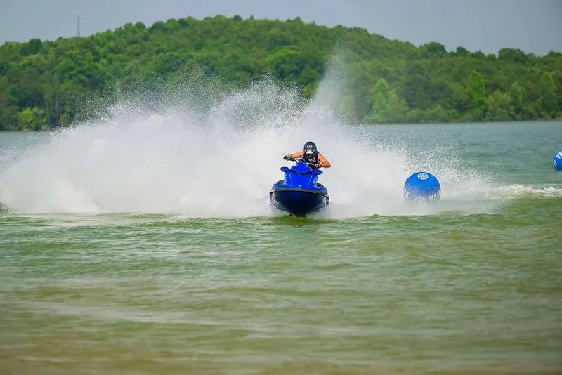 Slide: The Image of 2024 Yamaha WaveRunner GP SVHO speeding on a lake with lush green hills. - 8